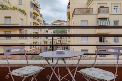 a table and chairs on a balcony with buildings at Damiani & Sister Guesthouse in Rome