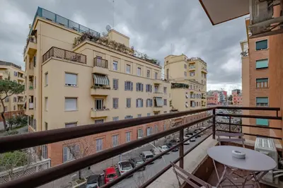 a balcony with a table and chairs and buildings at Damiani & Sister Guesthouse in Rome