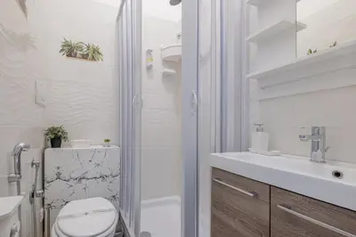 a white bathroom with a toilet and a sink at Damiani & Sister Guesthouse in Rome