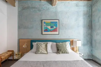 a bedroom with a bed with a blue wall at iFlat Vatican High-End Apartment in Rome