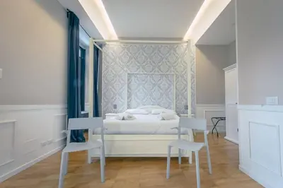 a bedroom with a bed and two chairs in it at Trastevere Glasshouse in Rome