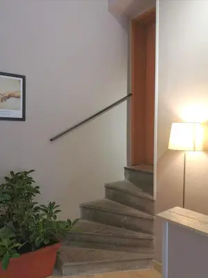 a staircase in a room with a lamp and a plant at Trastevere Glasshouse in Rome