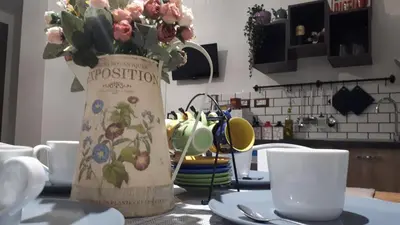 two vases with flowers on a table with cups and plates at Domus Angelica in Rome