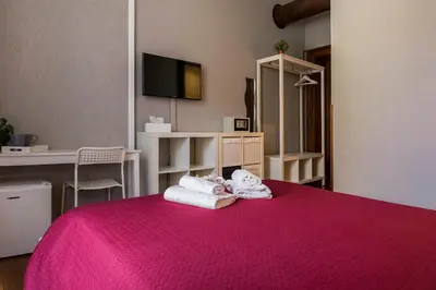 a bedroom with a pink bed with towels on it at Dulcis In Fundo b&b in Rome