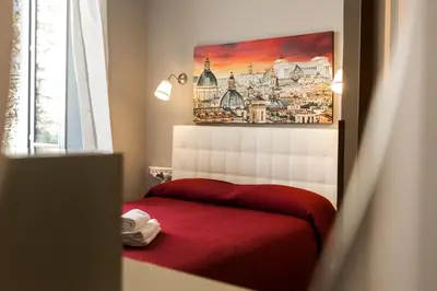a bedroom with a red bed and a painting on the wall at Dulcis In Fundo b&b in Rome