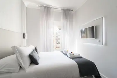 a white bedroom with a bed and a window at White Caesar Guesthouse in Rome