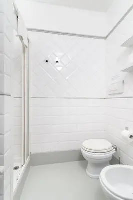 a white bathroom with a toilet and a sink at White Caesar Guesthouse in Rome