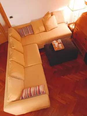 a living room with a yellow couch and a table at Borgo Pio San Pietro Apartment in Rome