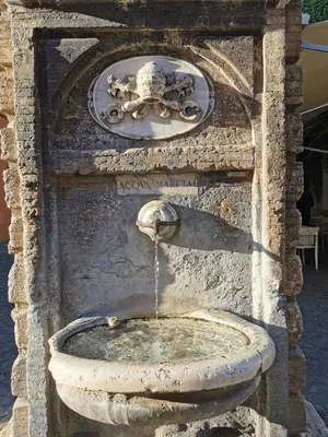 an old stone fountain with a water fall at Borgo Pio San Pietro Apartment in Rome
