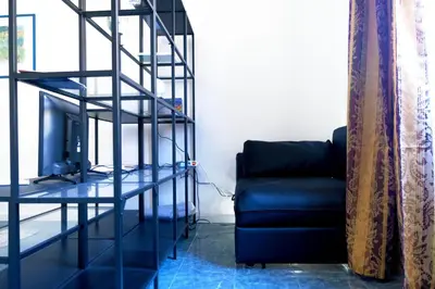 a living room with a blue couch and a television at Pimpinella in Rome