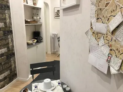 a dining room with a table and a wall with posters at LE FATE SUITES in Rome