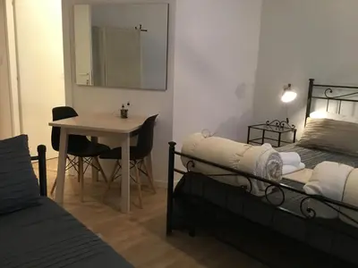 a room with two beds and a table and a mirror at LE FATE SUITES in Rome