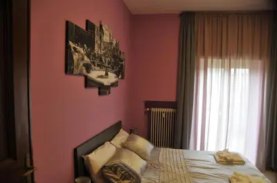 a bedroom with pink walls and a bed with pillows at RomAmoR in Rome