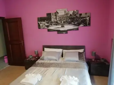 a bedroom with a bed with a pink wall at RomAmoR in Rome