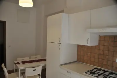 a kitchen with a white refrigerator and a table at RomAmoR in Rome