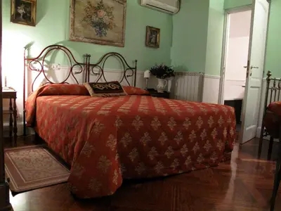 a bedroom with a large bed with a red blanket at Guest House Arco Dei Tolomei in Rome