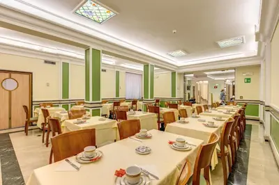 a dining room with tables and chairs and a window at Hotel Igea in Rome