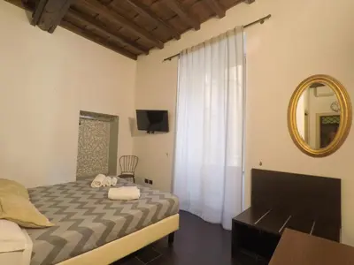 a bedroom with a bed and a mirror and a television at House Monti 1875 in Rome