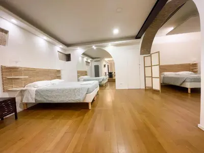two beds in a large room with wooden floors at La Pigna Boutique Apartment in Rome