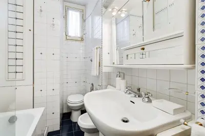 a white bathroom with a sink and a toilet at Elegant Apartment Rome in Rome