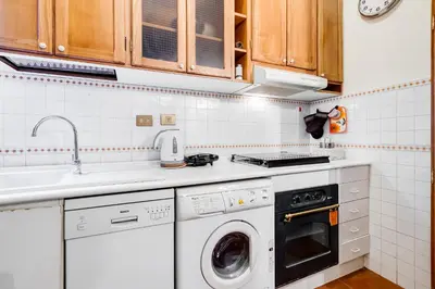 a kitchen with a washing machine and a sink at Elegant Apartment Rome in Rome