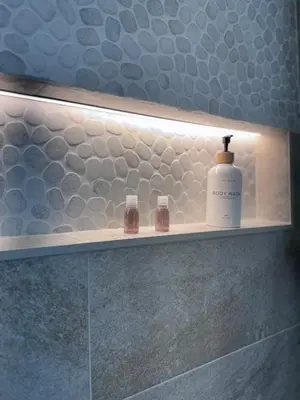 a bathroom shelf with a bottle of soap and two glasses at Living in Rome