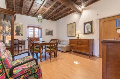 a dining room and living room with a table and chairs at GuestHost - Montecitorio & Pantheon Stylish Flat in Rome