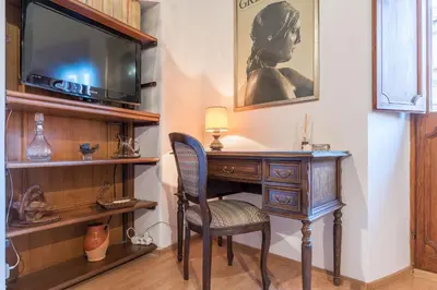 a desk with a chair and a television in a room at GuestHost - Montecitorio & Pantheon Stylish Flat in Rome