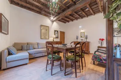 a living room with a table and chairs and a couch at GuestHost - Montecitorio & Pantheon Stylish Flat in Rome
