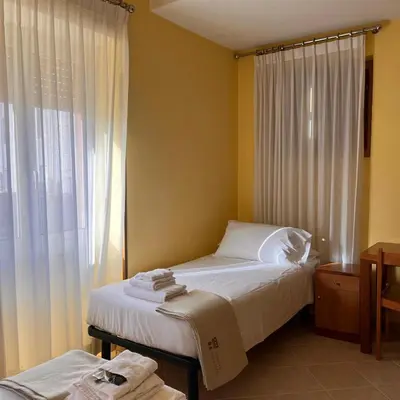 a bedroom with two beds and a window at La Casa di Nazareth in Rome
