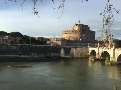 a boat on a river with a bridge and a building at Una finestra su Castel Sant'Angelo in Rome