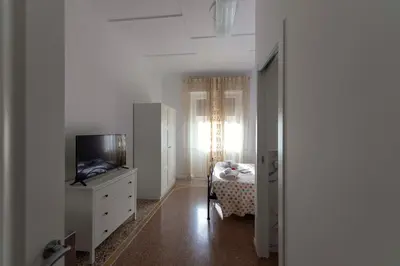 a room with a tv and a bedroom with a bed at Lo Sguardo sui Re in Rome