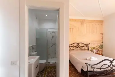 a bedroom with a bed and a bathroom with a shower at Lo Sguardo sui Re in Rome