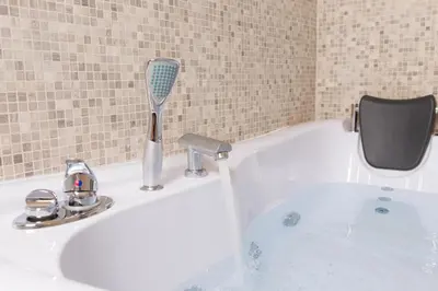 a bath tub with a faucet with water coming out at Suite House Vaticano in Rome