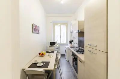 a kitchen with white appliances and a counter with a table at Vacanze romane holidays in Rome