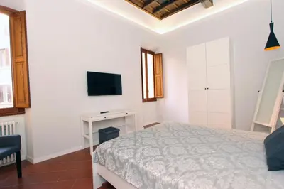 a bedroom with a bed and a tv on a wall at Monte Giordano Flats in Rome