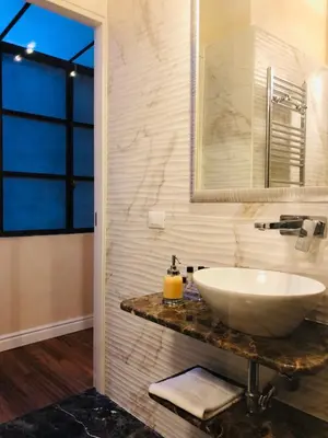 a bathroom with a white sink and a mirror at Luxury Apartment Frattina 34 Anelli in Rome