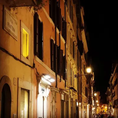 a city street at night with buildings and lights at Luxury Apartment Frattina 34 Anelli in Rome
