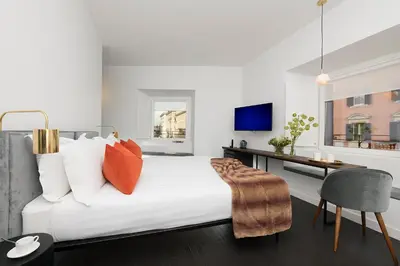 a bedroom with a bed with a desk and a chair at Maison Ottavia in Rome
