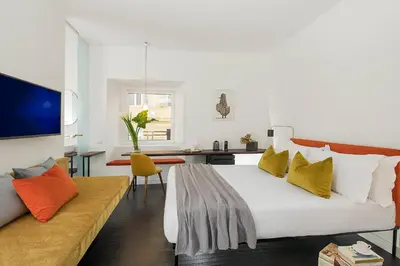 a bedroom with a large white bed and a couch at Maison Ottavia in Rome