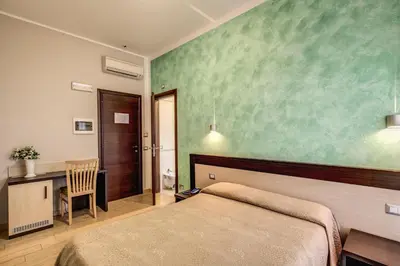 a bedroom with a bed and a desk and a table at Buonarroti Suite in Rome