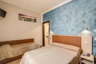 a bedroom with two beds and a blue wall at Buonarroti Suite in Rome