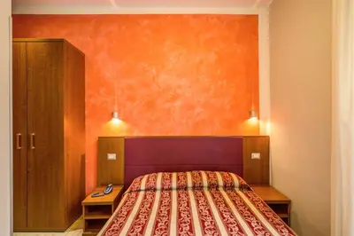 a bedroom with a bed with an orange wall at Buonarroti Suite in Rome