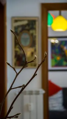 a branch of a plant in a room with paintings at Mid House in Rome