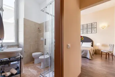 a bathroom with a sink and a toilet and a bed at Vatican Domus Luxury Rooms in Rome