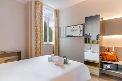 a hotel room with a white bed and a window at B&B Hotel Roma Pietralata Tiburtina in Rome