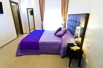 a purple bed with a purple comforter in a bedroom at Domus Fontis in Rome