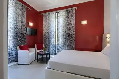 a bedroom with a white bed and a red wall at Alloggio per uso turistico D'Ambrosio Antonella Gli Scipioni 53 in Rome