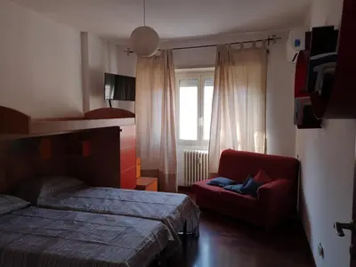 a bedroom with a bed and a red chair at Checchi House in Rome