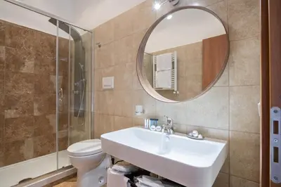 a bathroom with a sink and a toilet and a mirror at Vatican Domus Smart Rooms in Rome